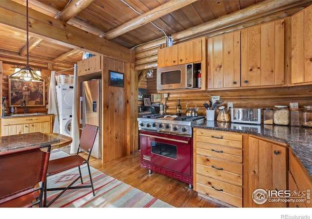 kitchen with stacked washer and clothes dryer, wooden ceiling, log walls, and stainless steel appliances