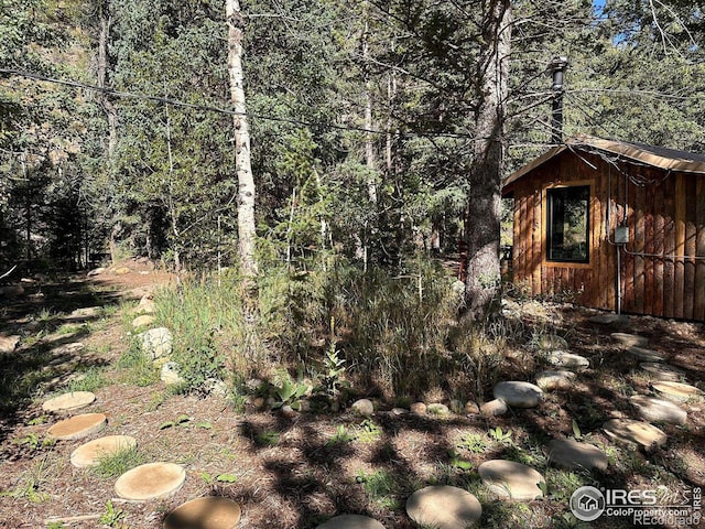 exterior space with an outbuilding and a wooded view