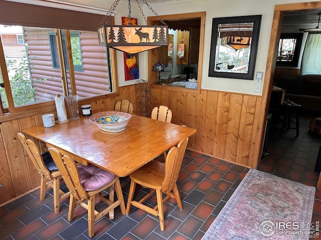 dining area with a wainscoted wall and wood walls