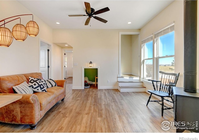 living area with light wood-type flooring, ceiling fan, baseboards, and recessed lighting