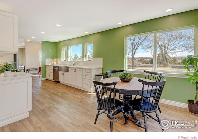 dining room featuring light wood-style floors, baseboards, a wealth of natural light, and recessed lighting