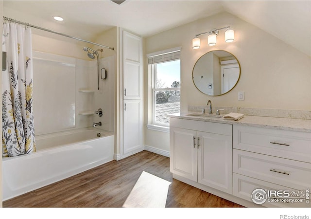 bathroom with lofted ceiling, vanity, wood finished floors, and shower / bath combo with shower curtain