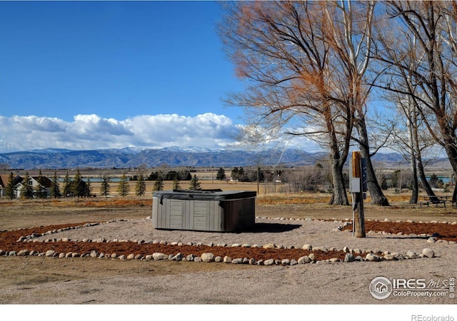 view of yard with a mountain view and a hot tub