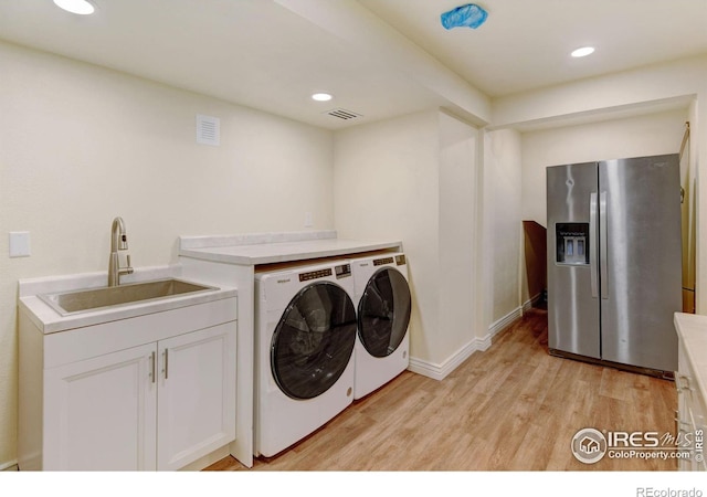 washroom featuring visible vents, light wood-style flooring, separate washer and dryer, a sink, and recessed lighting