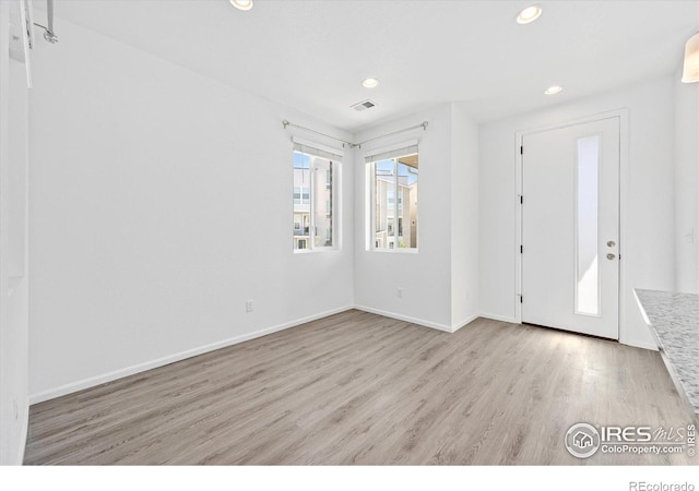 entryway featuring baseboards, wood finished floors, visible vents, and recessed lighting