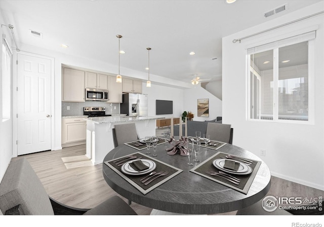 dining space featuring light wood-type flooring, ceiling fan, visible vents, and recessed lighting