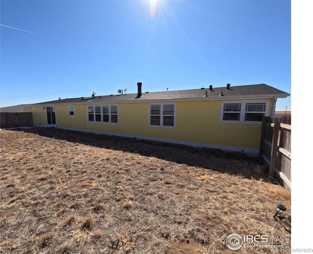 back of house with fence