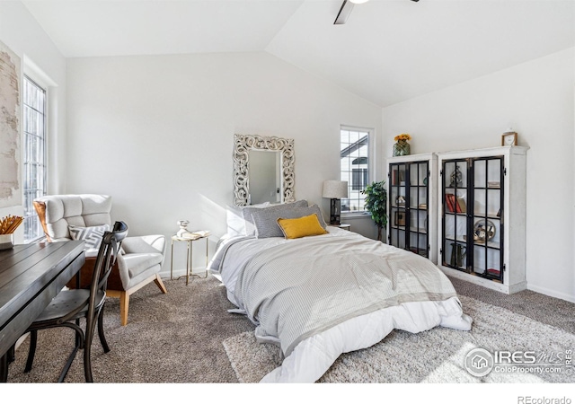 carpeted bedroom with vaulted ceiling, multiple windows, a ceiling fan, and baseboards