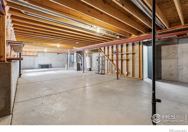 unfinished basement featuring heating unit and gas water heater