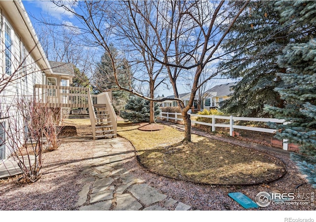 view of yard with stairway, fence, and a wooden deck