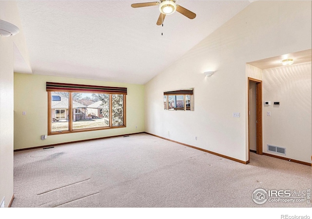 spare room with baseboards, visible vents, ceiling fan, carpet flooring, and high vaulted ceiling