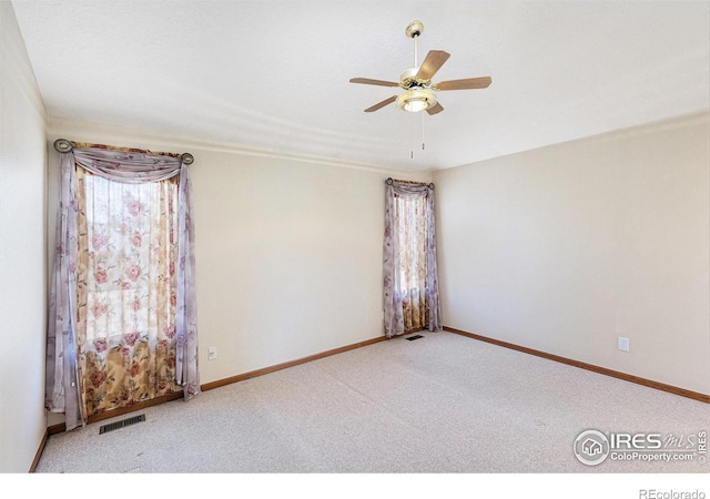 unfurnished room featuring ceiling fan, carpet floors, visible vents, and baseboards