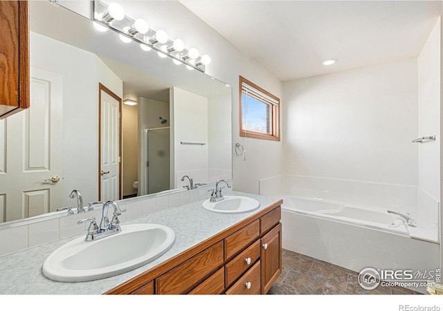 full bathroom with double vanity, a sink, a bath, and a shower stall