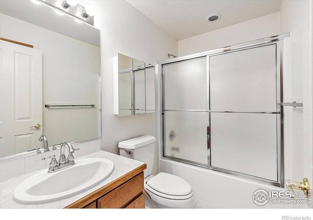 bathroom with shower / bath combination with glass door, vanity, and toilet