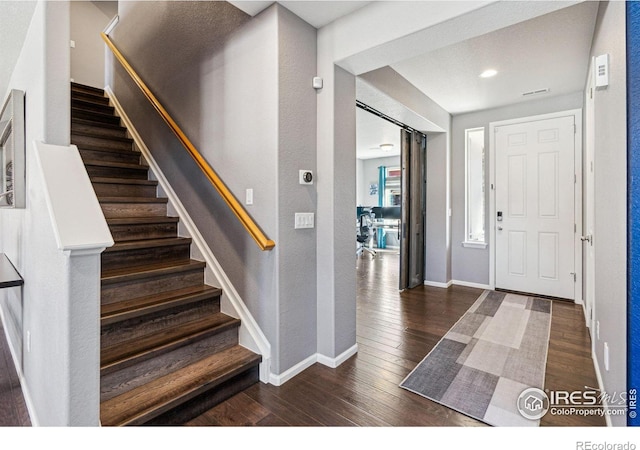 entryway featuring stairs, baseboards, and wood finished floors