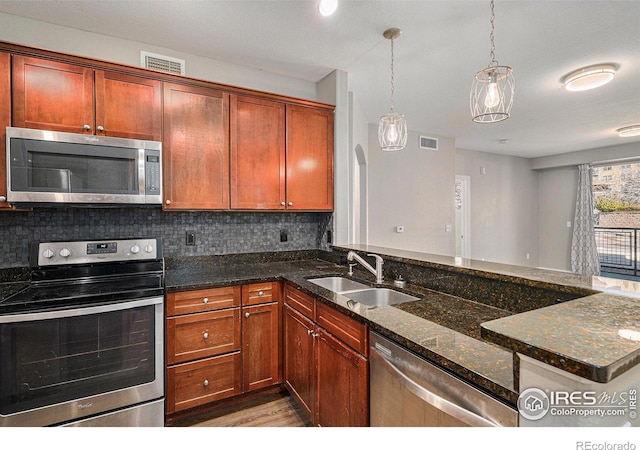 kitchen with arched walkways, stainless steel appliances, a sink, visible vents, and decorative backsplash