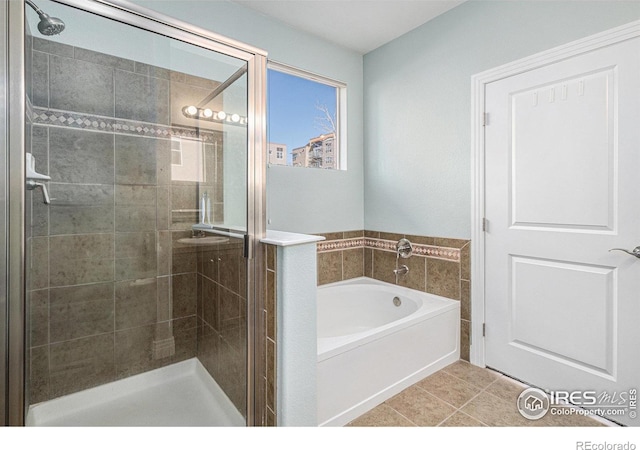 bathroom with a shower stall, a bath, and tile patterned floors