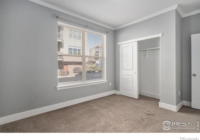 unfurnished bedroom with carpet floors, crown molding, and baseboards