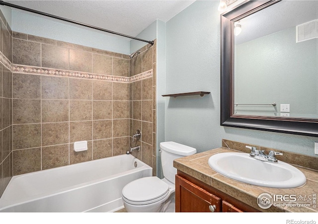 bathroom featuring visible vents, toilet, bathtub / shower combination, a textured ceiling, and vanity