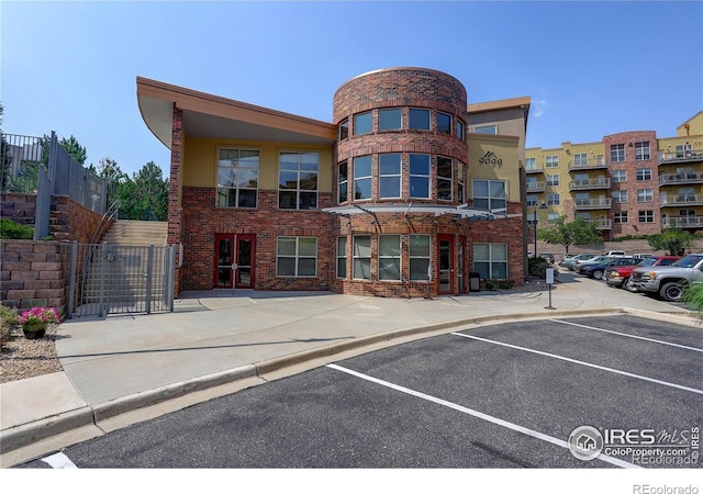 view of building exterior featuring uncovered parking and fence