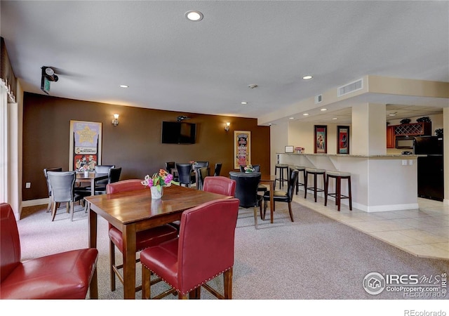 dining space featuring light colored carpet, visible vents, and recessed lighting