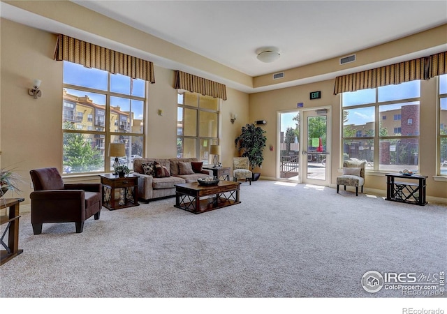 living area featuring carpet flooring, visible vents, and baseboards