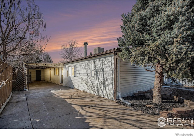 back of property featuring a carport and fence