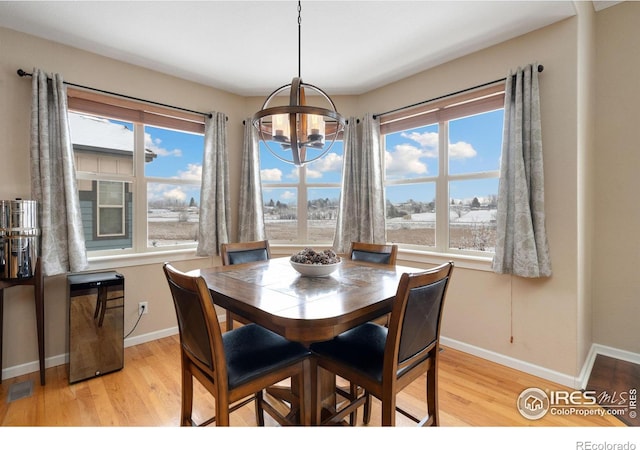 dining space featuring light wood-type flooring, plenty of natural light, and baseboards