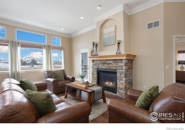 living room featuring visible vents, ornamental molding, wood finished floors, and a stone fireplace