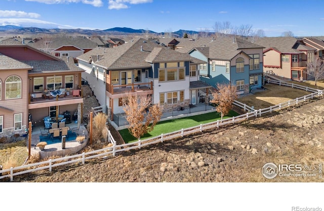 rear view of property with a fenced backyard, a residential view, a mountain view, and a patio