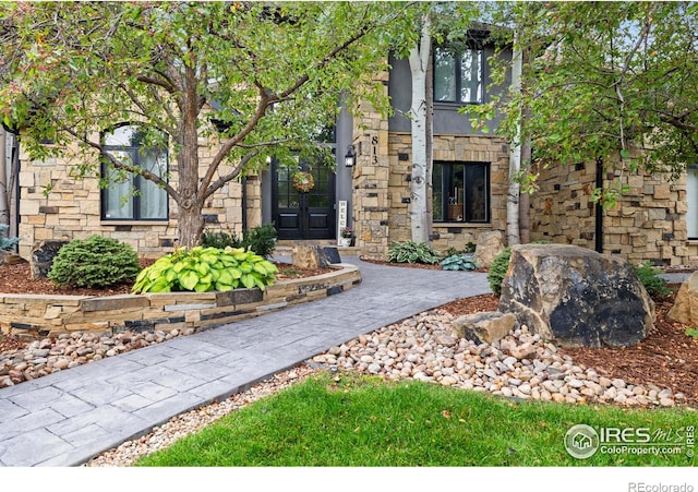 doorway to property featuring french doors and stone siding