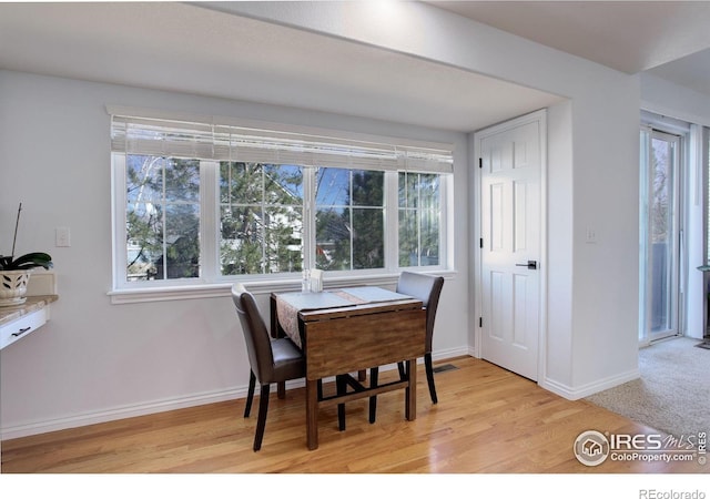 dining area with light wood-style flooring and baseboards