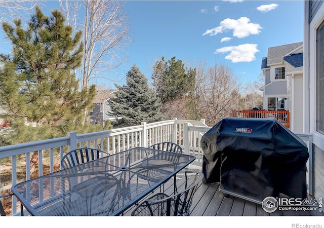 wooden deck with outdoor dining space and grilling area