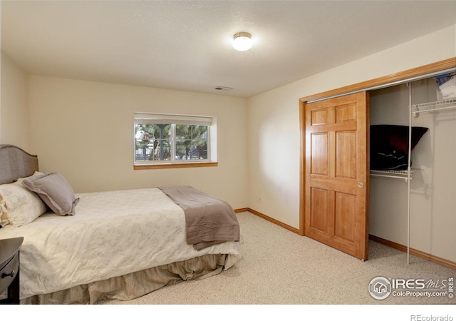 carpeted bedroom with baseboards, visible vents, and a closet