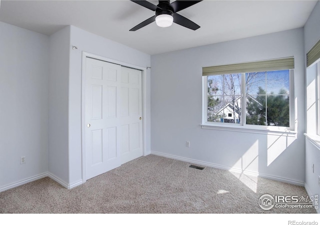 unfurnished bedroom featuring a ceiling fan, baseboards, visible vents, and carpet flooring