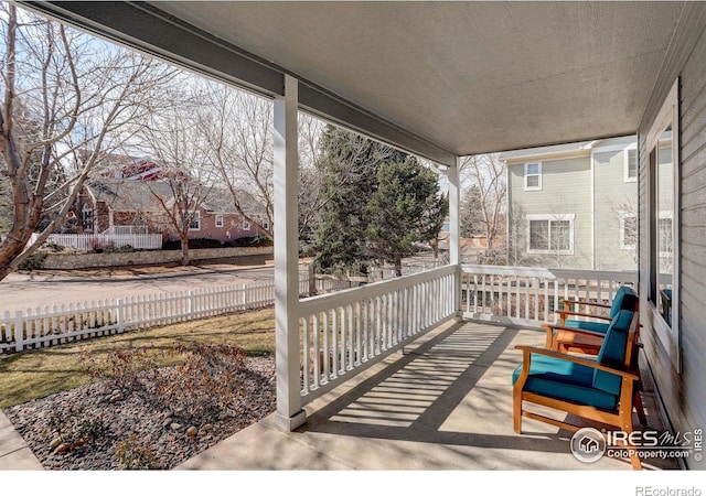 view of patio featuring a porch and fence