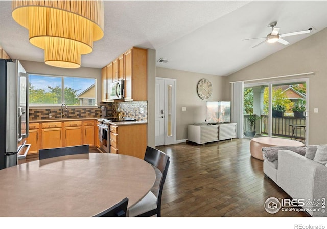 kitchen featuring stainless steel appliances, a wealth of natural light, open floor plan, and a sink