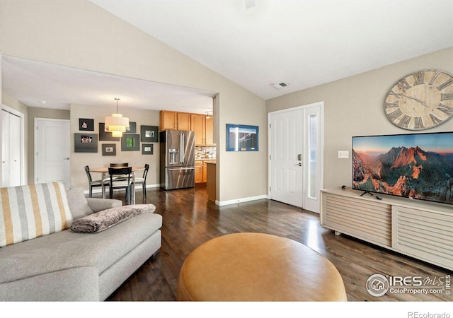 living area with lofted ceiling, dark wood finished floors, visible vents, and baseboards