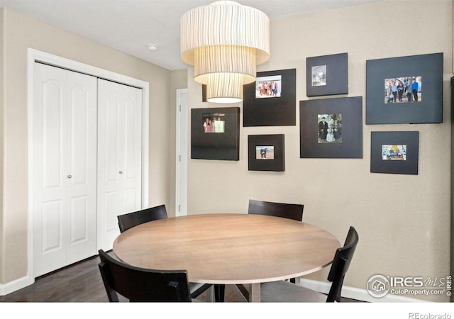 dining space featuring baseboards and wood finished floors