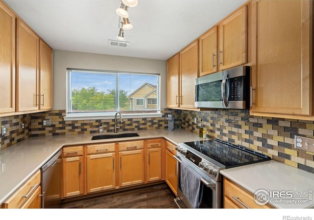 kitchen featuring visible vents, decorative backsplash, appliances with stainless steel finishes, light countertops, and a sink