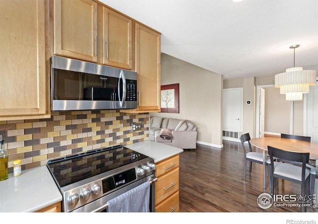 kitchen featuring visible vents, appliances with stainless steel finishes, dark wood-style flooring, light countertops, and backsplash