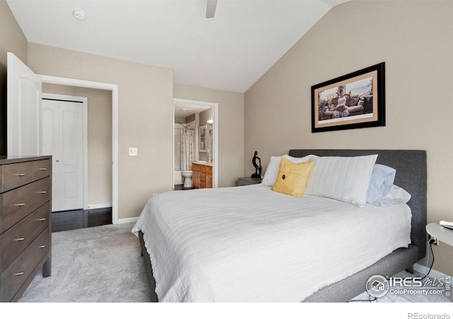 carpeted bedroom featuring vaulted ceiling, ensuite bath, a ceiling fan, and baseboards