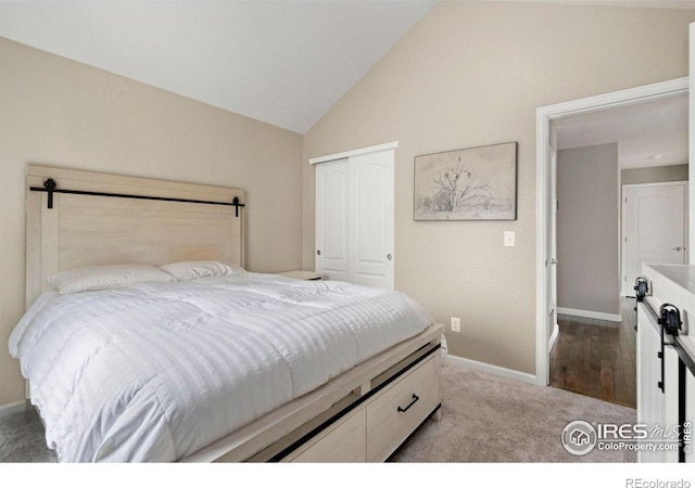 carpeted bedroom with vaulted ceiling, a closet, and baseboards