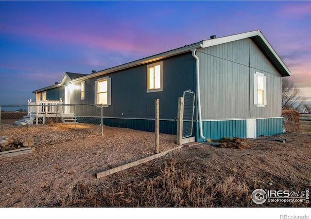 property exterior at dusk featuring fence