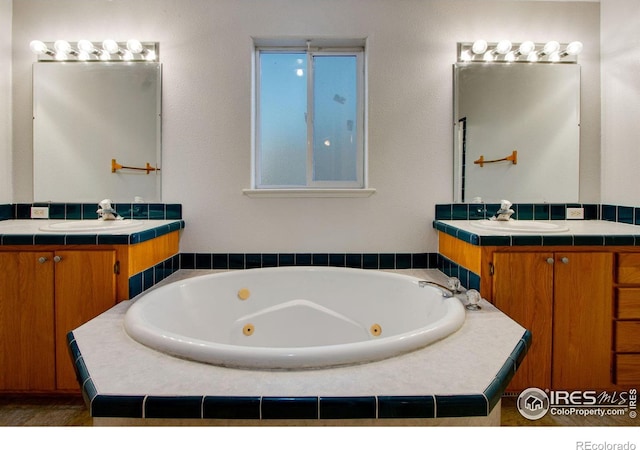 bathroom featuring a whirlpool tub, two vanities, and a sink