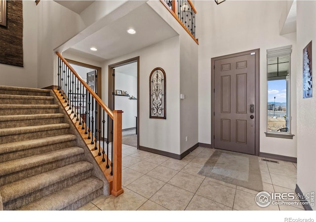 foyer entrance with light tile patterned floors, recessed lighting, visible vents, baseboards, and stairway