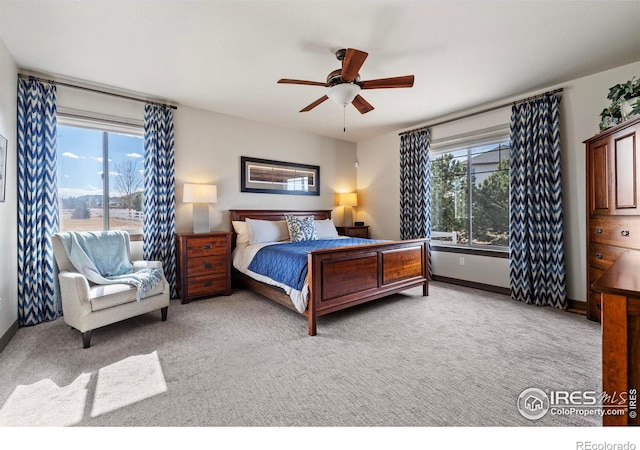 bedroom with ceiling fan, multiple windows, baseboards, and carpet flooring