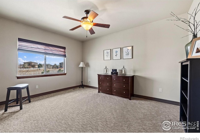 living area with a ceiling fan, baseboards, and carpet flooring