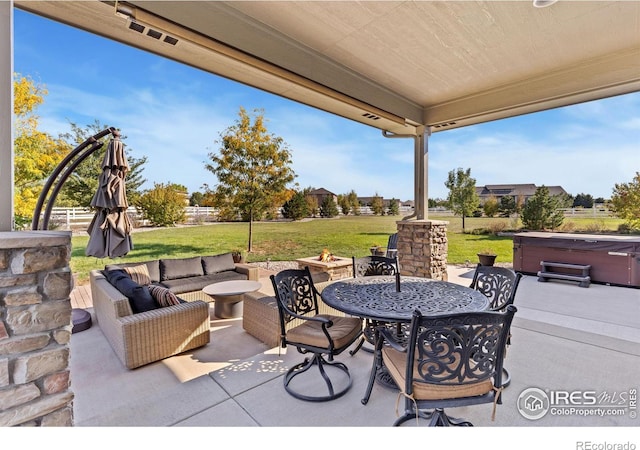 view of patio / terrace with outdoor dining space, a hot tub, and an outdoor living space with a fire pit