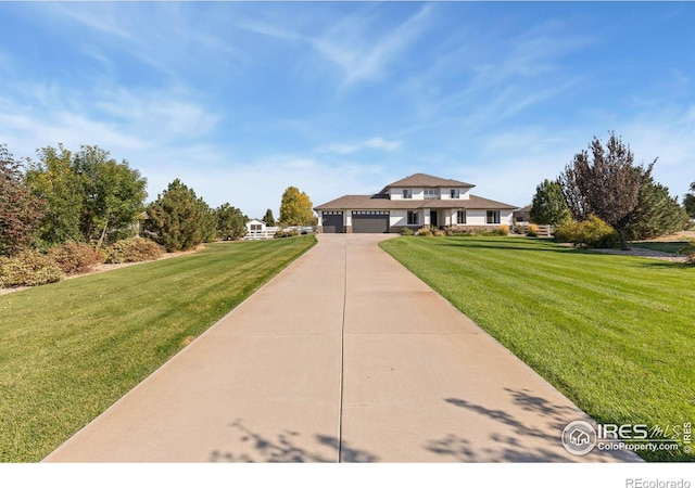 view of front of home with a garage, concrete driveway, and a front lawn